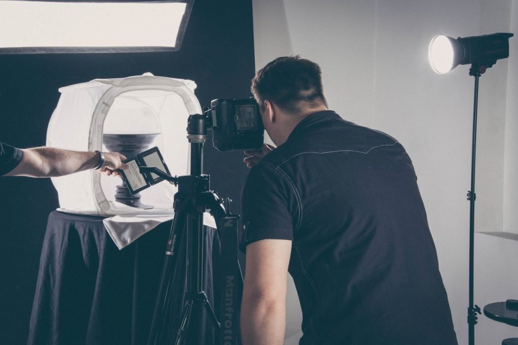 man-taking-picture-of-person-s-left-arm-1391786 Photographer capturing product in a studio setup with lighting gear and camera.